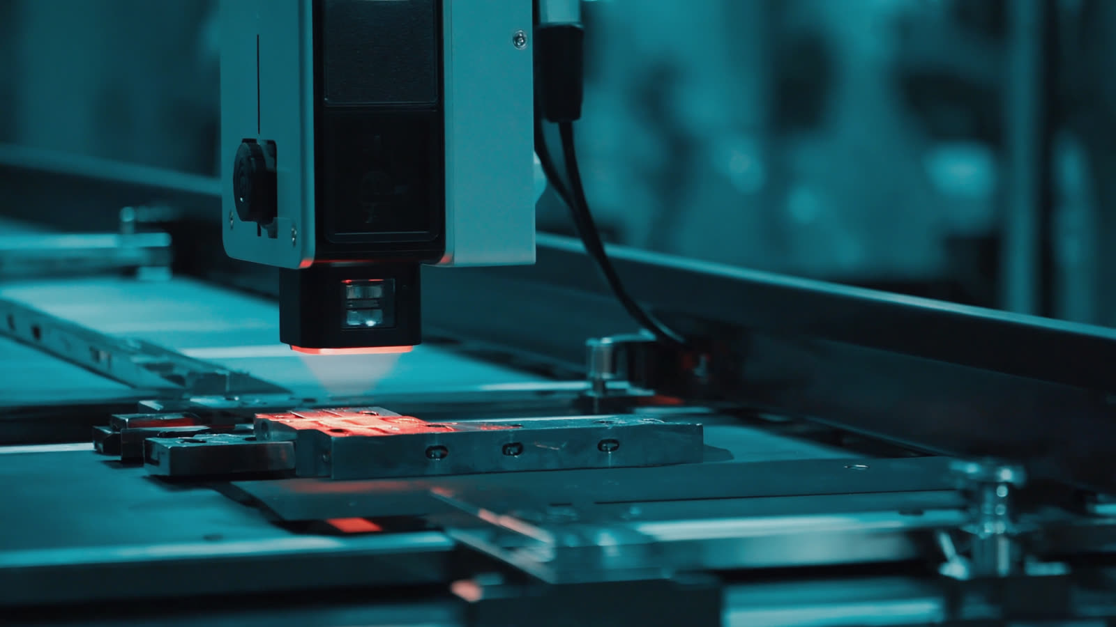 Machine-vision camera projecting a red scanning line onto a part on a conveyor